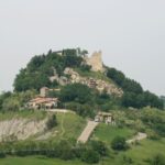 Ruiny zamku Canossa na wzgórzu wśród zielonych wzgórz Emilii-Romanii, miejsce pokuty cesarza Henryka IV przed papieżem Grzegorzem VII w 1077 roku.